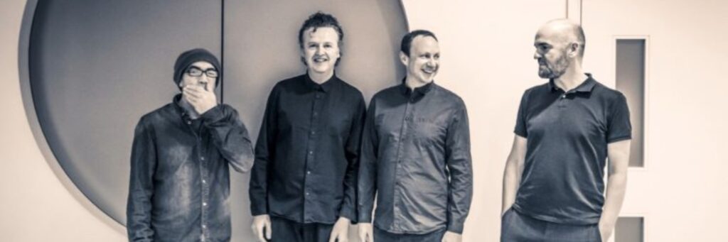 four people shown, the dominant colour of the image is grey