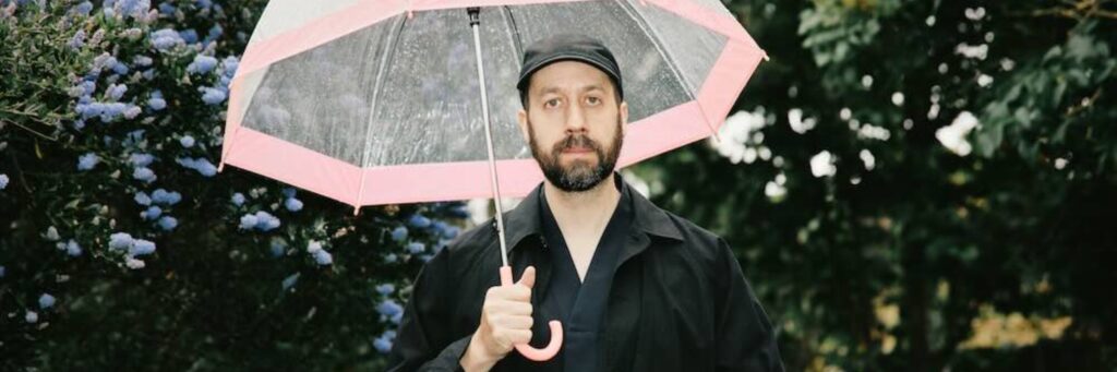 One soloist shown, outdoors, with an umbrella
